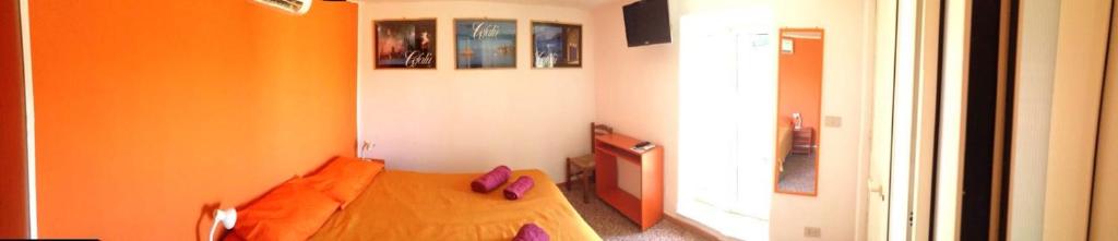 a bedroom with a wooden bed with purple shoes on it at Appartamento Osnao in Cefalù