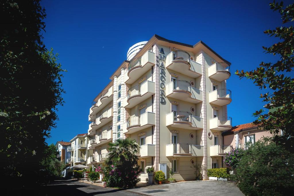 a tall apartment building with a blue sky in the background at Hotel Residence Amarcord in Rimini