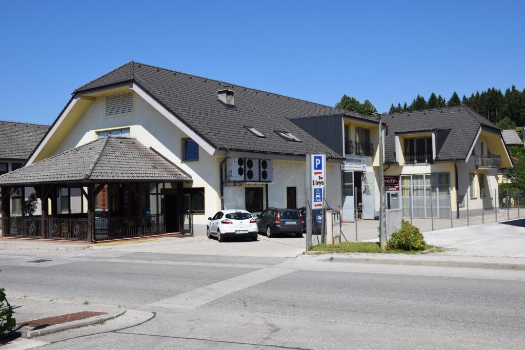 a building on a street with cars parked in front of it at Hostel Novak in Novo Mesto