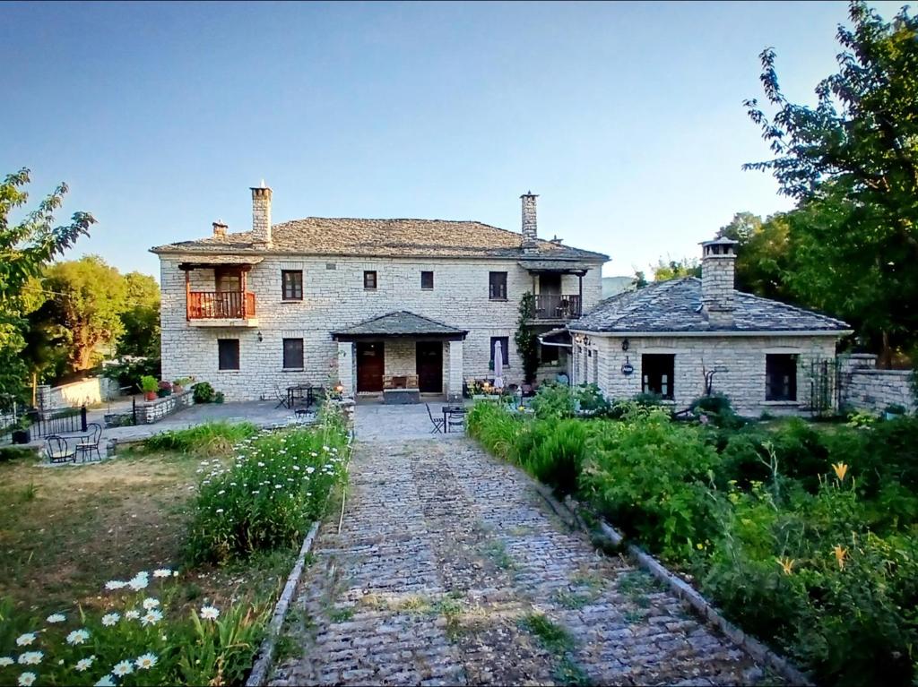 una casa vieja con una pasarela de piedra delante de ella en Aloni Guesthouse, en Ano Pedina