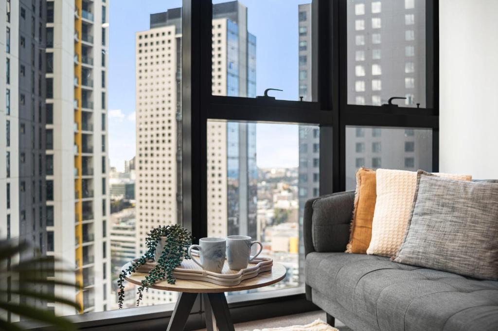 a couch and a coffee table in front of a window at Chic 1BR Southbank Apt Near Crown Casino in Melbourne
