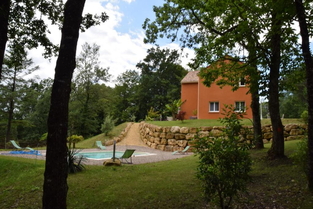 una casa con piscina y un patio con árboles en La Colline des Endrevies, en Saint-André-dʼAllas