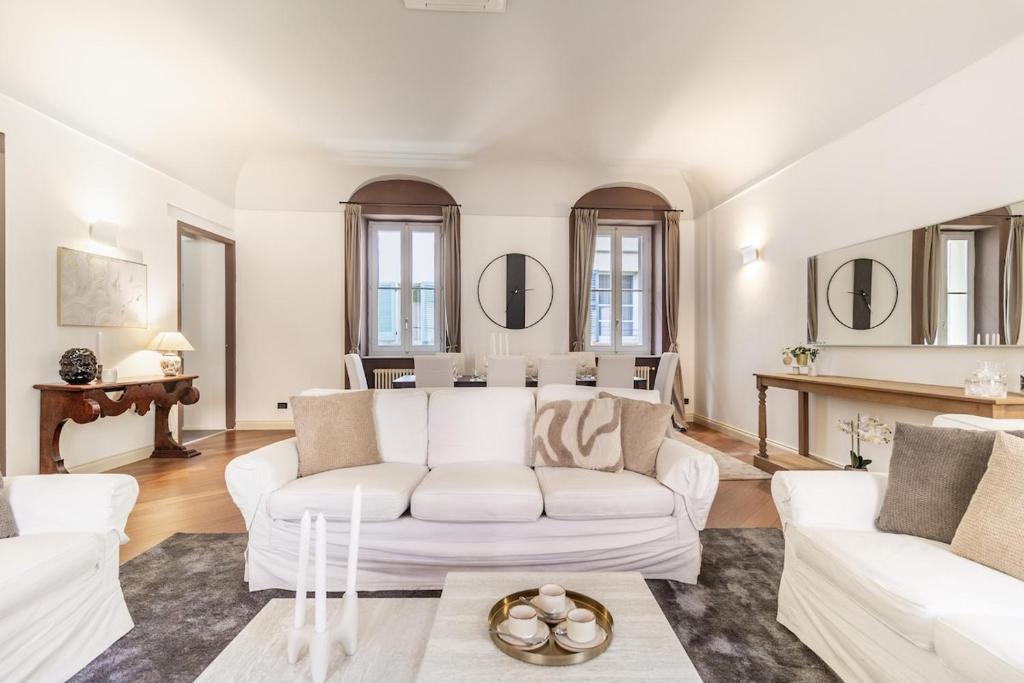 Duomo 3 Floors Penthouse في كومو: غرفة معيشة بأثاث ومرايا بيضاء