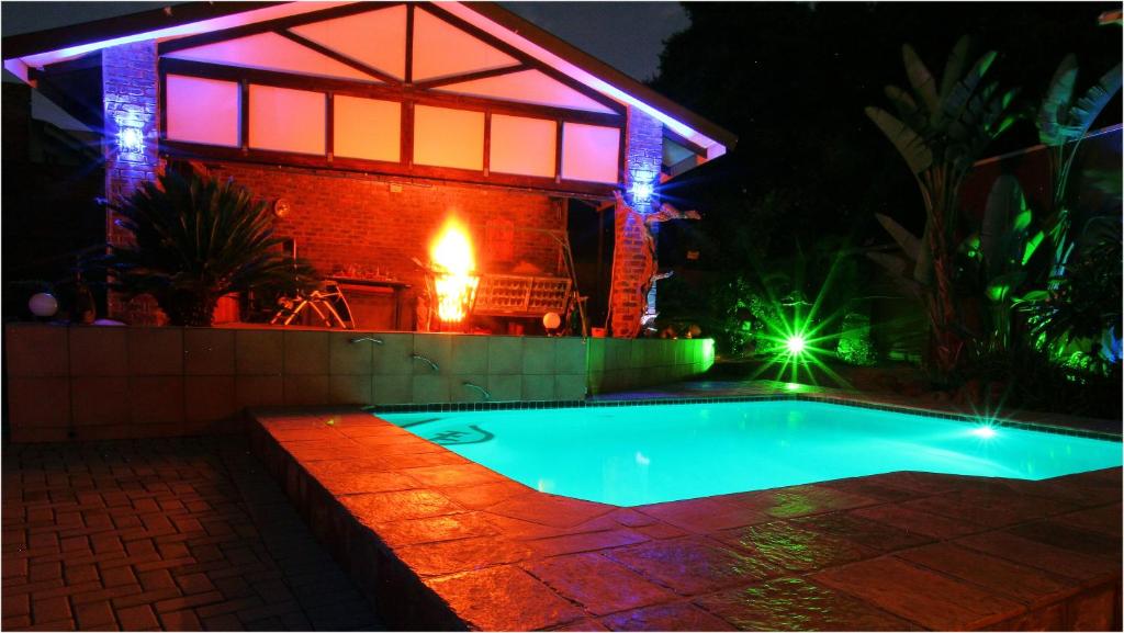 una piscina frente a una casa por la noche en In Between Home en Lydenburg