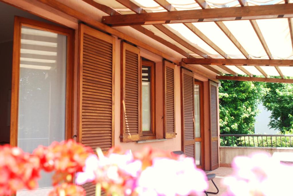 a patio with a wooden pergola and windows at Beija-Flor b&b in Verano Brianza