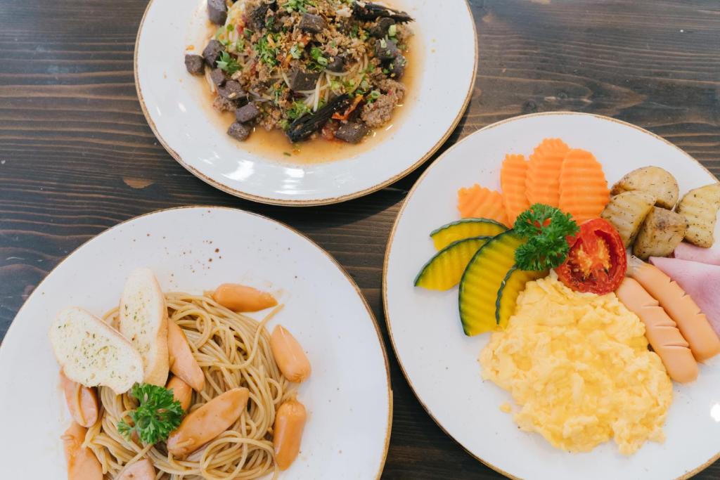 Three plated dishes showing pasta, a savory entrée and a full breakfast plate.