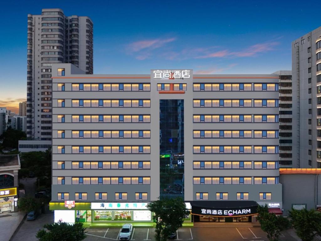 a large building with a sign on top of it at Echarm Hotel Haikou Friendship Sunshine City Wanlvyuan Branch in Haikou