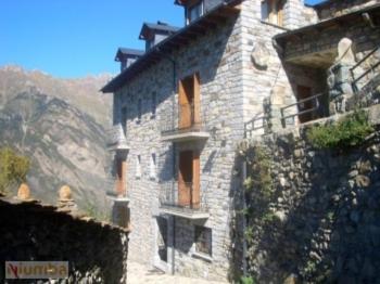 a large stone building with windows on a mountain at Casa La Abadía in Cerler