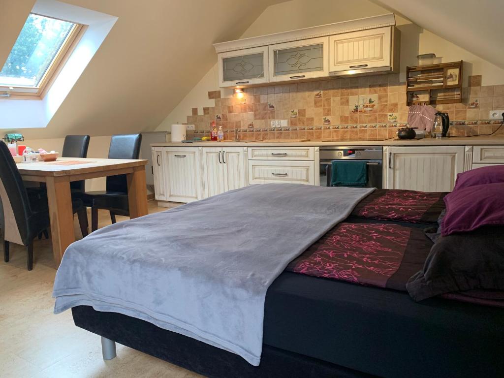 a bedroom with a bed and a kitchen with a table at Studio z kominkiem Leśna sauna i balia Cieszyn Wisła Ustron w zasięgu ręki in Simoradz