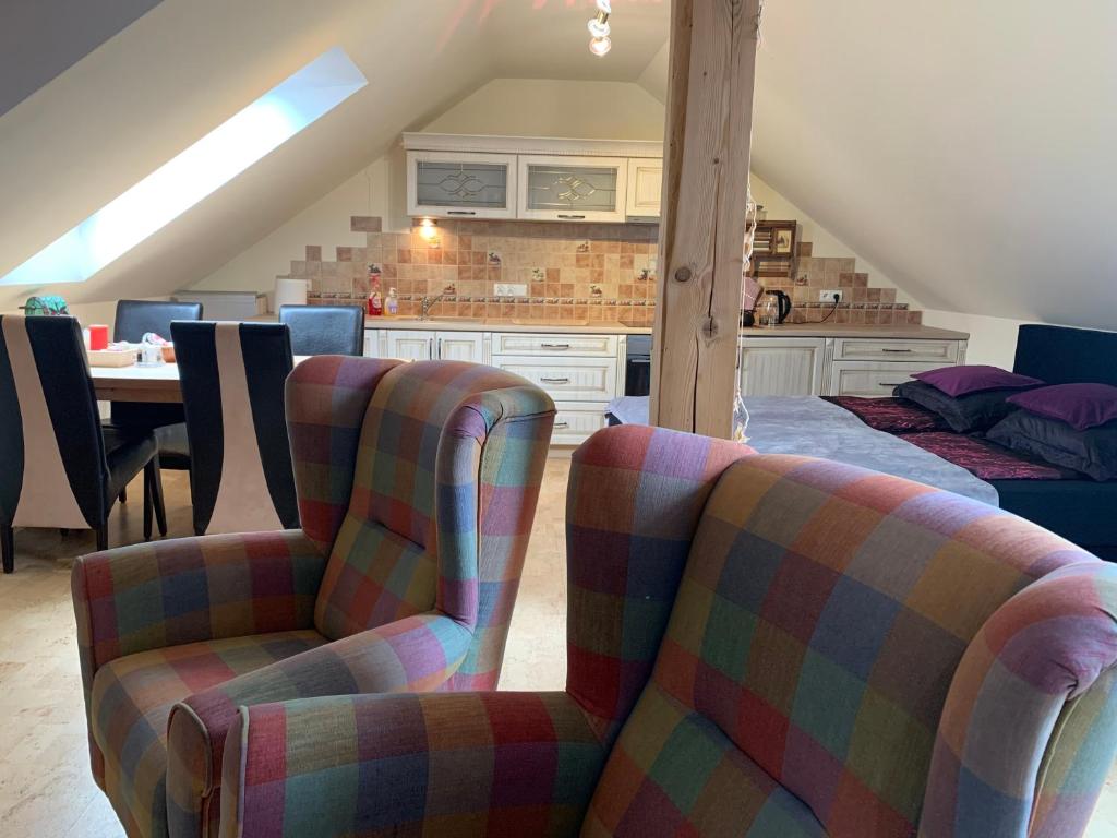 a living room with two chairs and a kitchen at Studio z kominkiem Sauna Jacuzzi Balia Ogrodowa in Simoradz