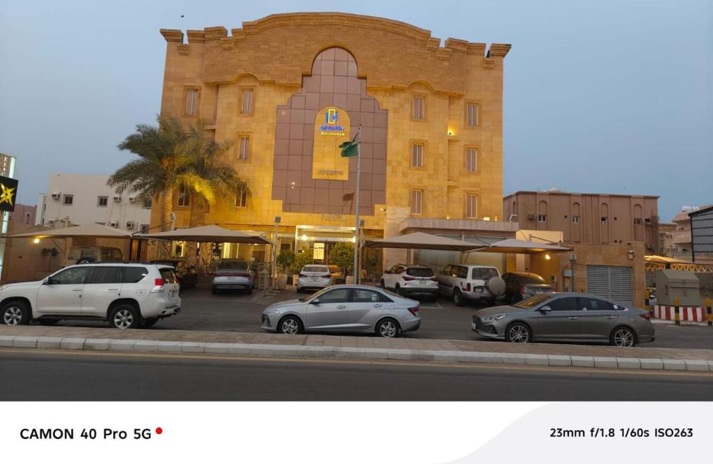 Un edificio con coches aparcados en un estacionamiento. en جولدن نيو-Golden New, en Jazan