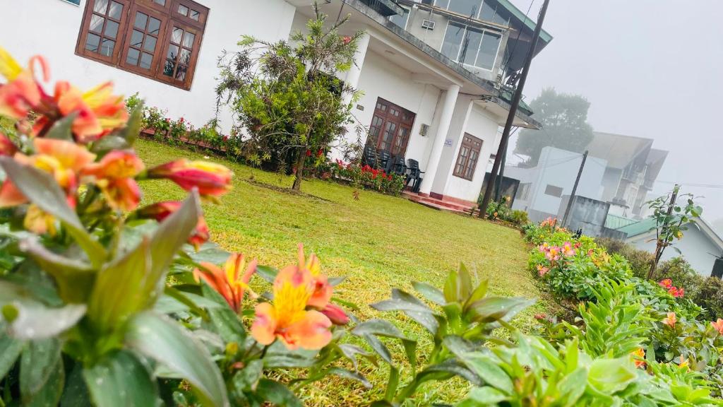 un giardino con fiori davanti a una casa di Gregory Lake Inn Resort a Nuwara Eliya