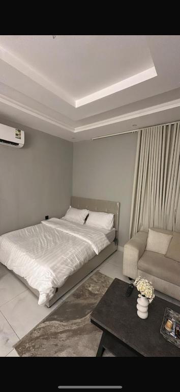 a bedroom with a bed and a couch and a table at استديو 3 دخول ذاتي in Jeddah