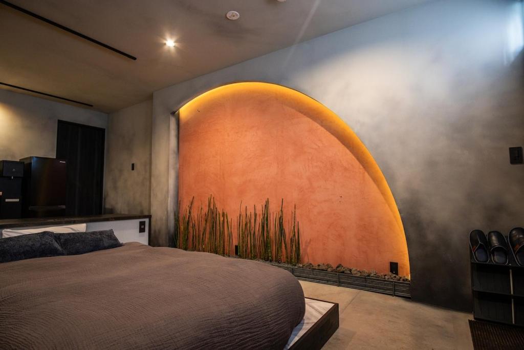 a bedroom with a bed with a painting on the wall at vacation house KAGO in Fujiyoshida