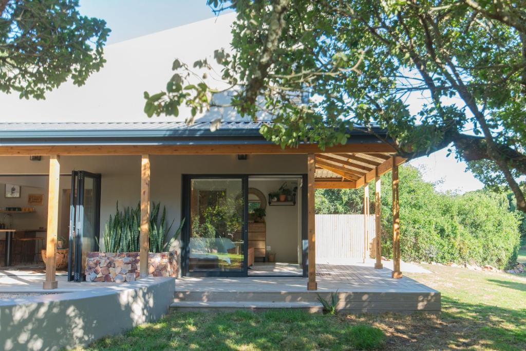 a home with a porch and glass doors at Weaver's Nest Cottage - Nature Retreat! in Gqeberha