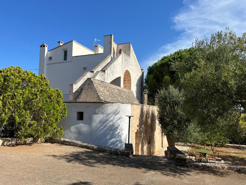 a large white building with a tree in front of it at Cascina Filomena in Polignano a Mare