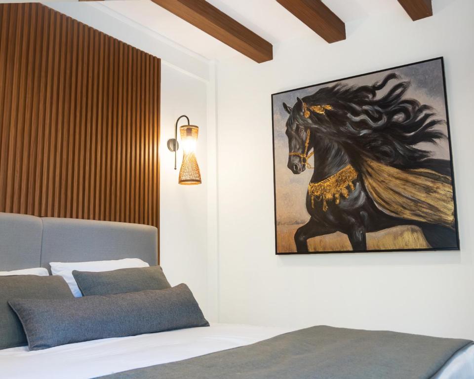 een slaapkamer met een schilderij van een paard aan de muur bij Edra House in Alacati