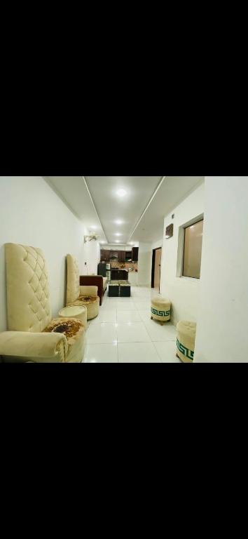 a living room with two chairs and a couch at Awais real estate in Rawalpindi