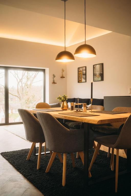a dining room with a wooden table and chairs at Ferienhaus Schöne Aussicht Schwarz in Edertal
