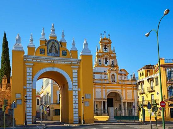 a yellow building with a clock tower on a street at Budget and lovely rooms Macarena B in Seville