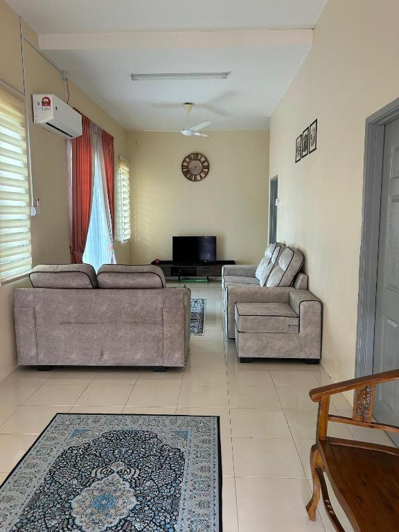 a living room with two couches and a tv at Singgah homestay in Gua Sai