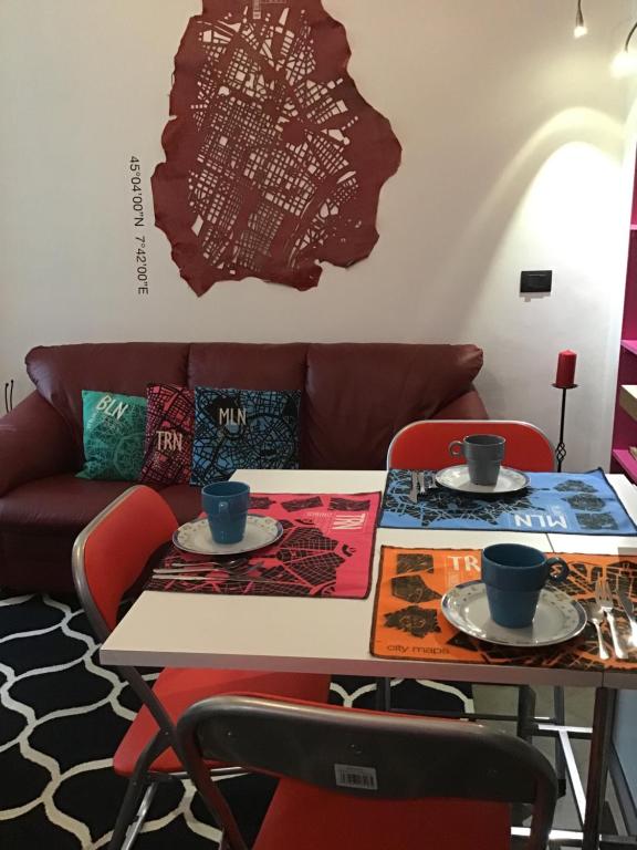 a living room with a table and a couch at Flat Liberty Turin center Porta Susa, reserved parking in Turin