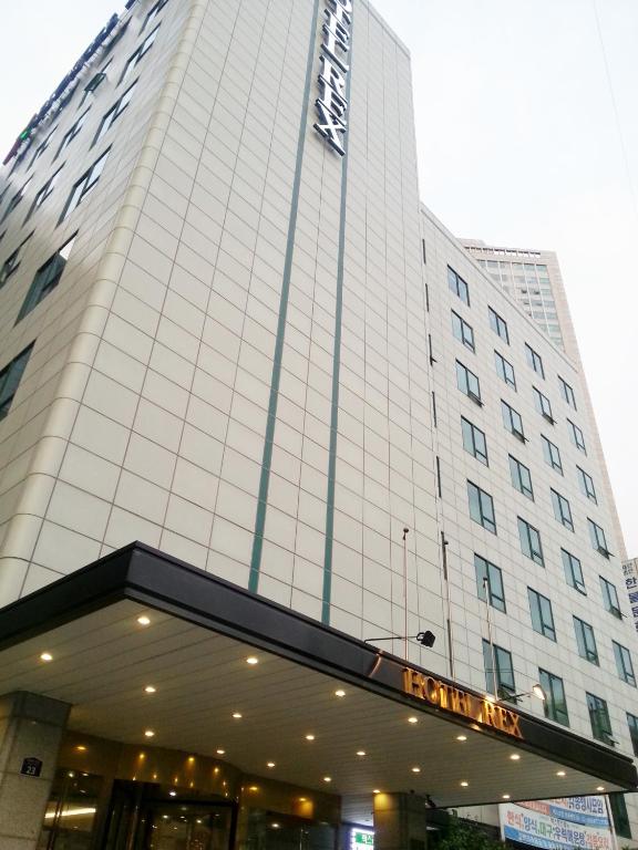 a tall white building with a sign on it at Seoul Rex Hotel in Seoul