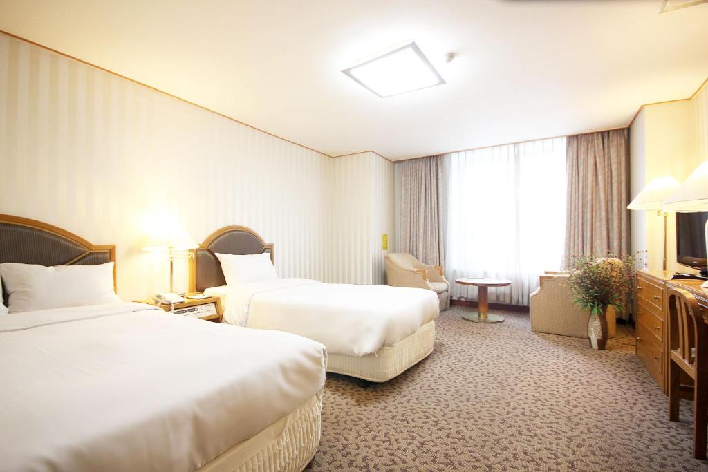 a hotel room with two beds and a television at Seoul Rex Hotel in Seoul