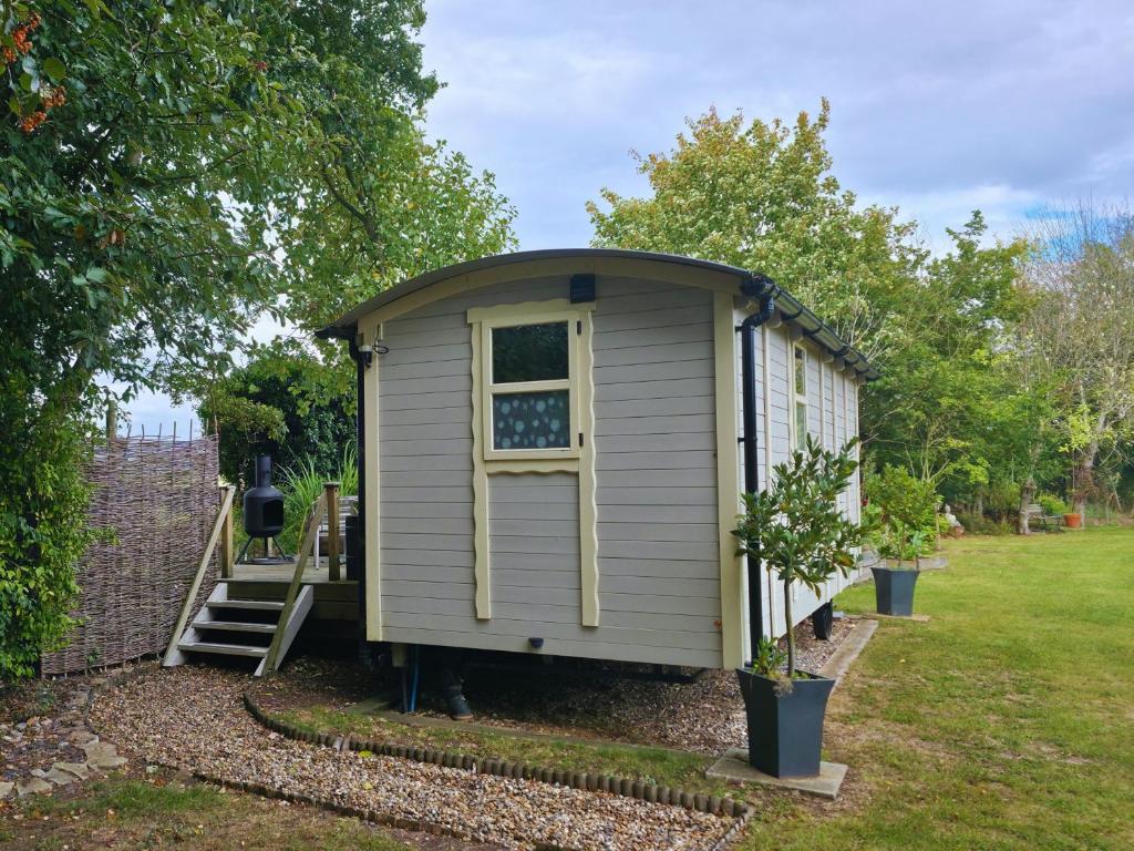 a small shed with a window in a yard at The Pheasant in Great Ellingham
