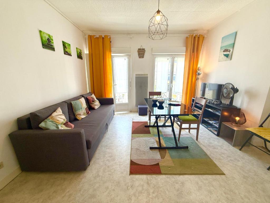 a living room with a couch and a table at L'Evasion, proche plage Foncillon - Royan in Royan
