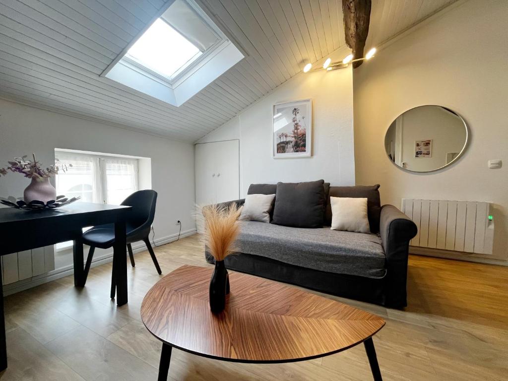 una sala de estar con un sofá y una mesa en POLKE - appartement 3 personnes - check in h24 - wifi, en Lyon