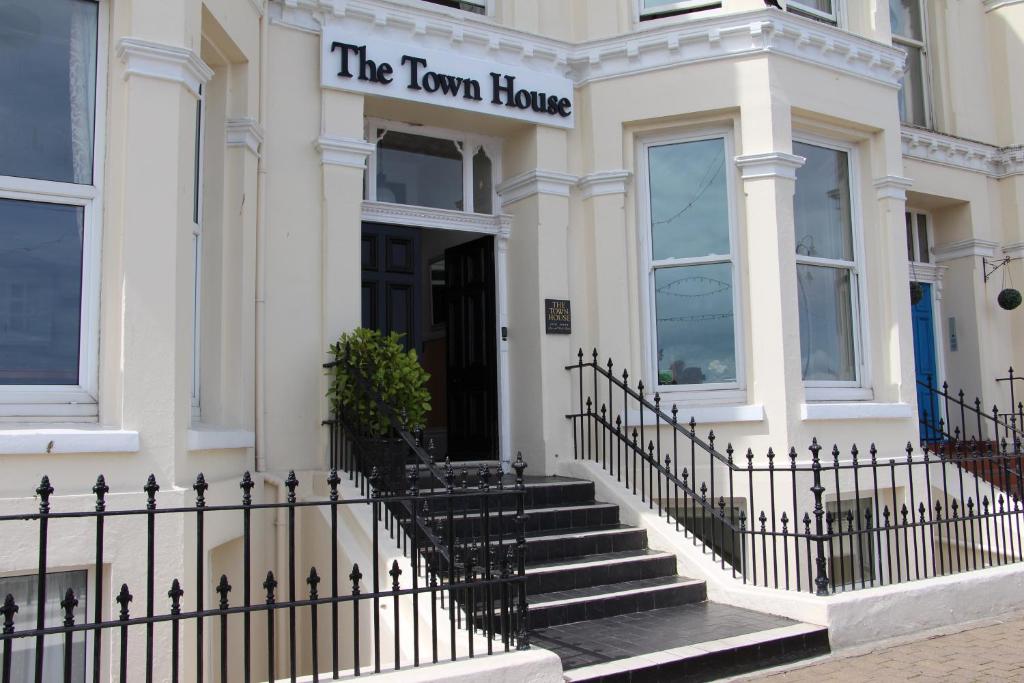 un edificio blanco con un cartel que lee la casa del pueblo en The Town House, en Douglas