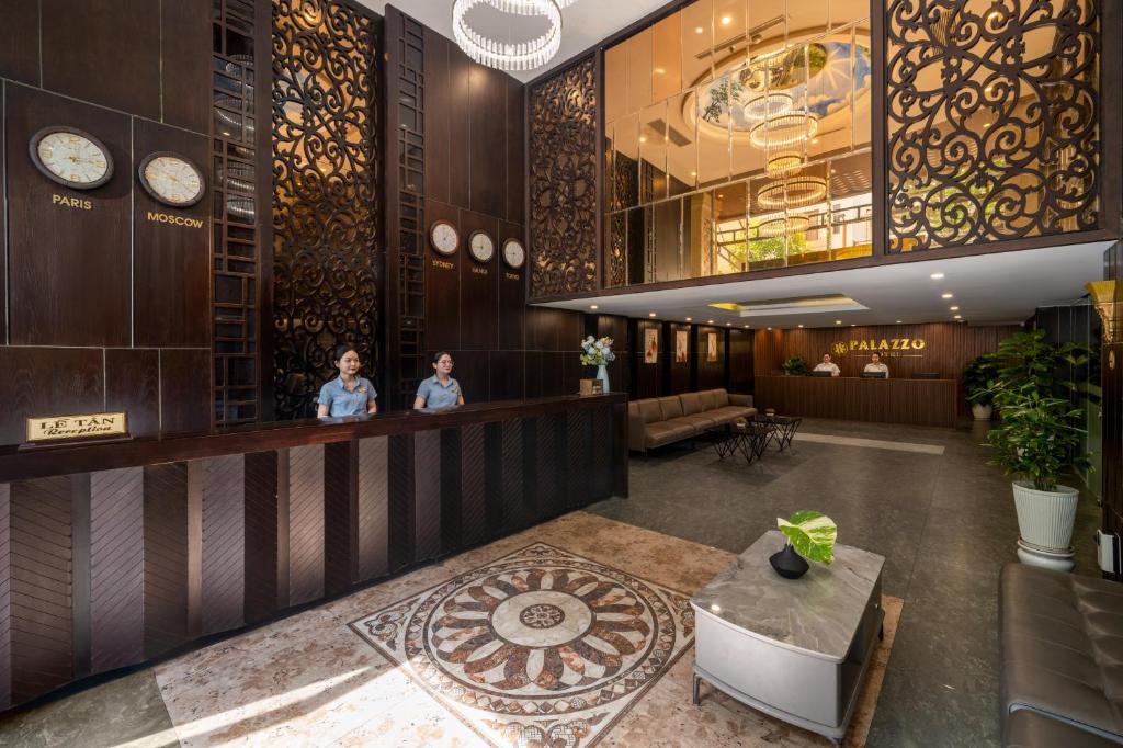 A richly decorated reception lobby with a long front desk and lounge seating.
