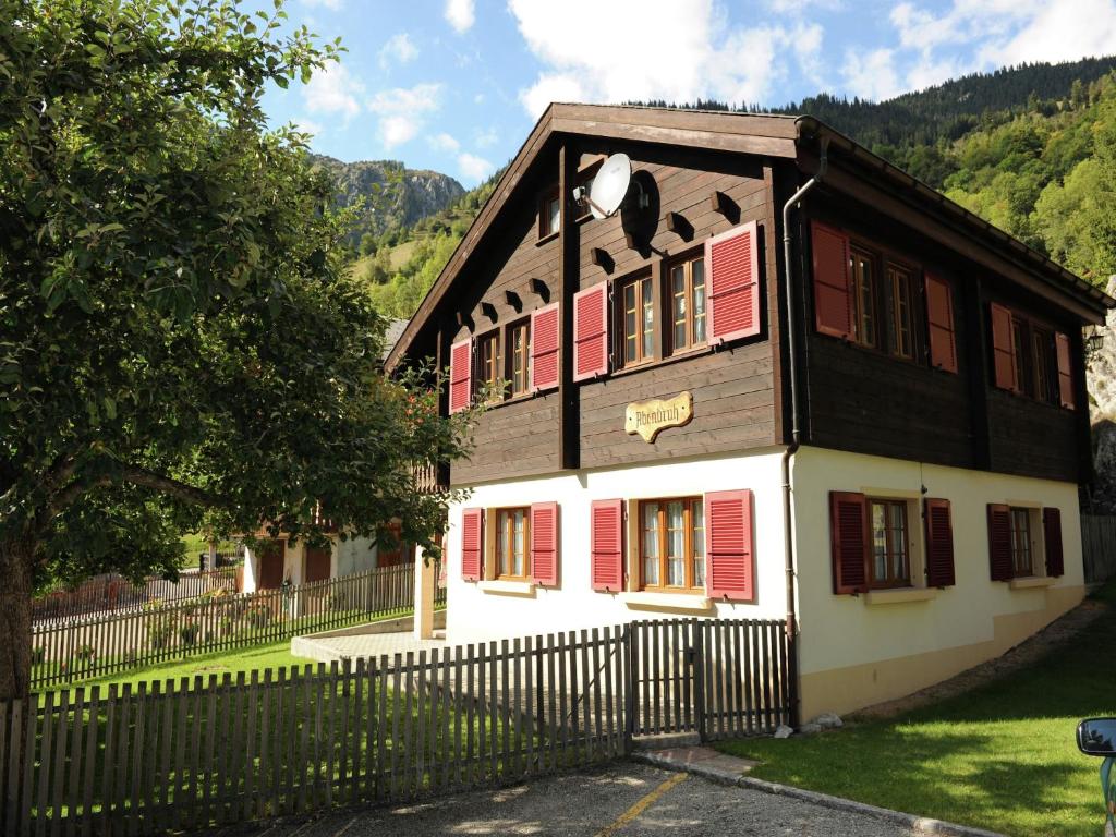 a house with red shuttered windows and a fence at Glacier Views & Ski Trails in Blatten bei Naters
