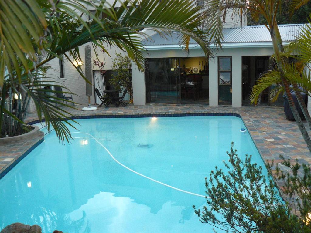 a large blue swimming pool in front of a house at See More Guest House in East London