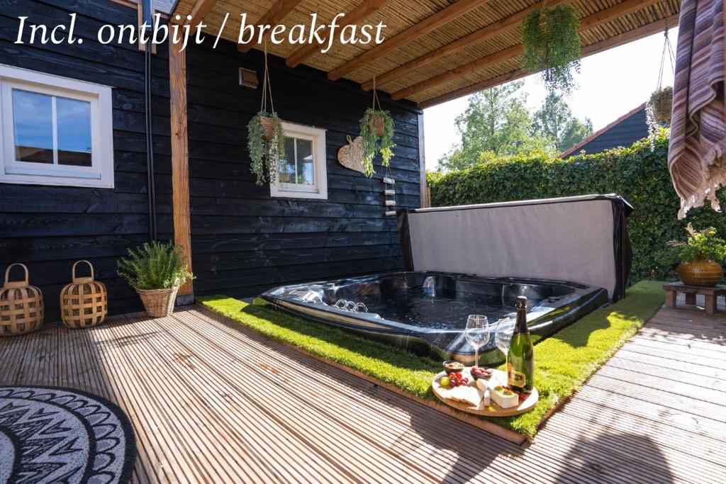a backyard with a hot tub in the grass at B&B The Wellness Cottage in Dordrecht