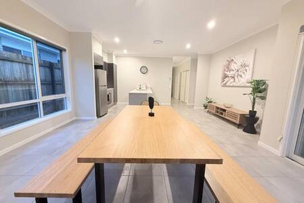 a large room with a wooden table in it at Silky Oak Stay - Brand New House in Griffin in Griffin