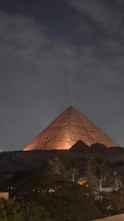 a pyramid is lit up at night at GRAND MuseuM HoteL in Cairo
