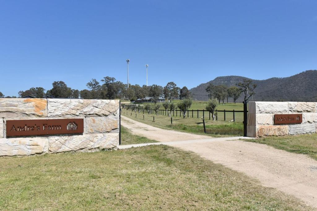 a dirt road with a sign next to a fence at Andres Farm Cottage in Broke