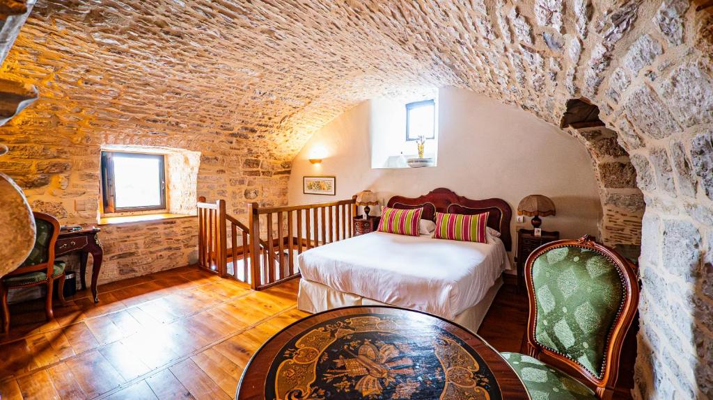 a bedroom with a bed and a stone wall at Château Hôtel La Terrasse - Teritoria in Meyronne