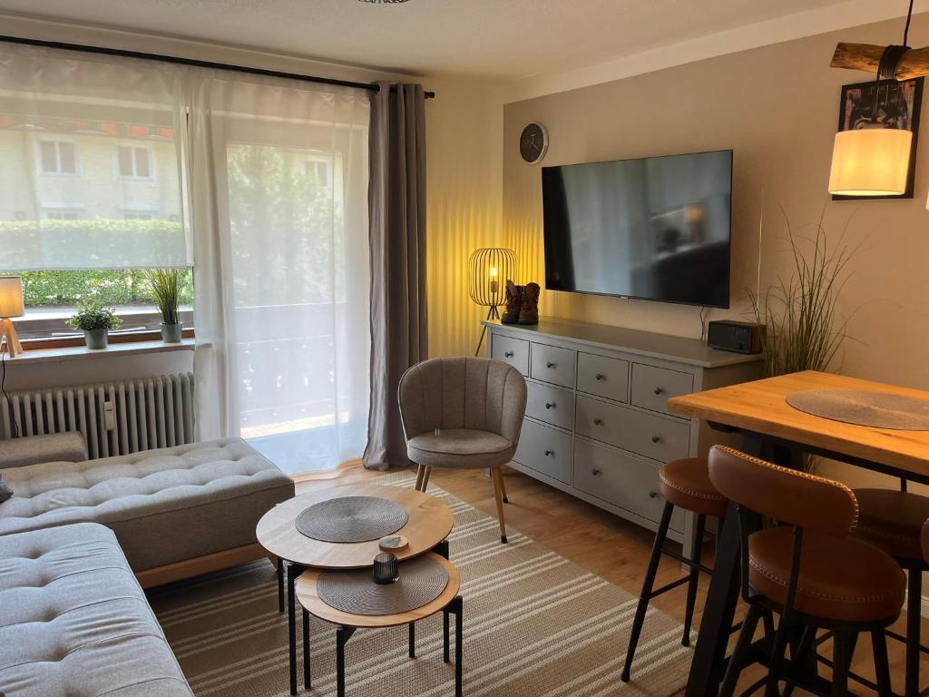 a living room with a couch and a tv at BergHerz Allgaeu in Sonthofen