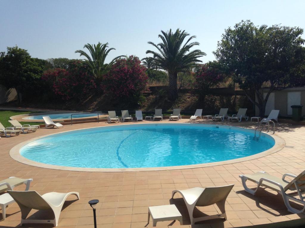 a large swimming pool with chairs and chairs in a resort at Vilamar in Luz