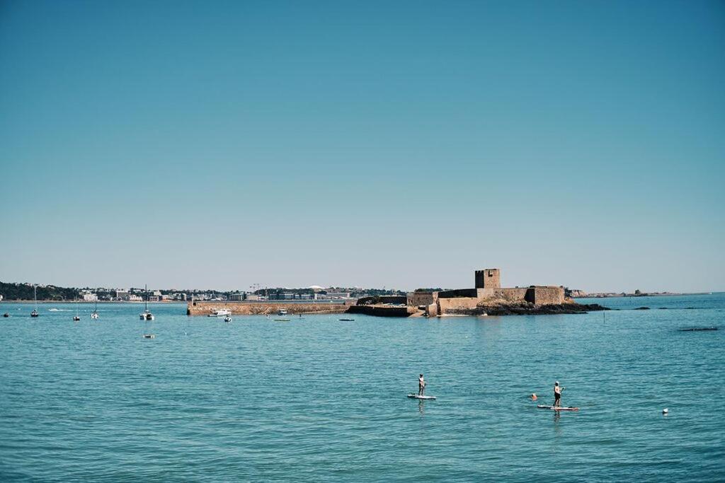 a group of people on paddle boards in the water at Large one bedroom beach apartment in Bel Royal