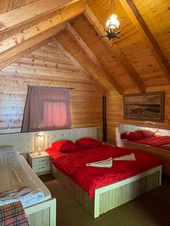 a bedroom with two beds in a wooden cabin at Villa Gryka in Peje