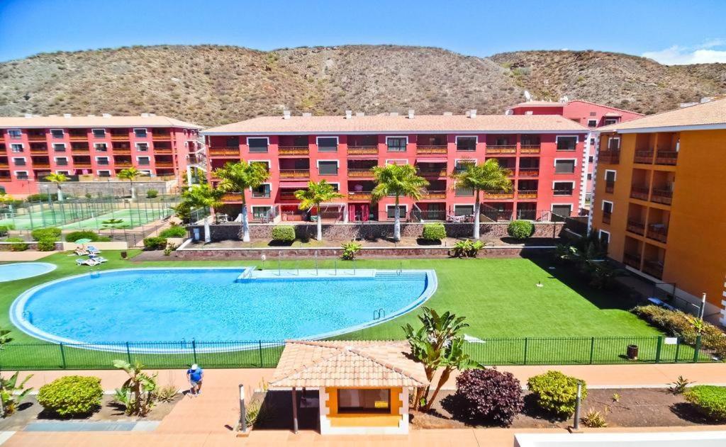 Un complejo con una gran piscina y edificios. en Apartamento de lujo en Residencial El Mocan, en Palm-mar