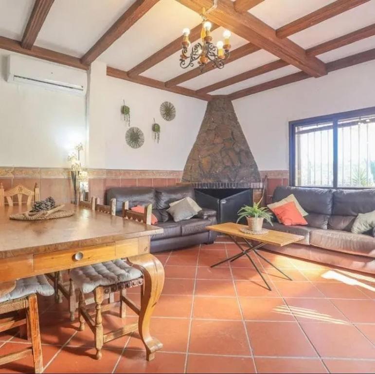 a living room with a couch and a table at Spacious Villa in Guillena with Garden and Private Pool in Guillena