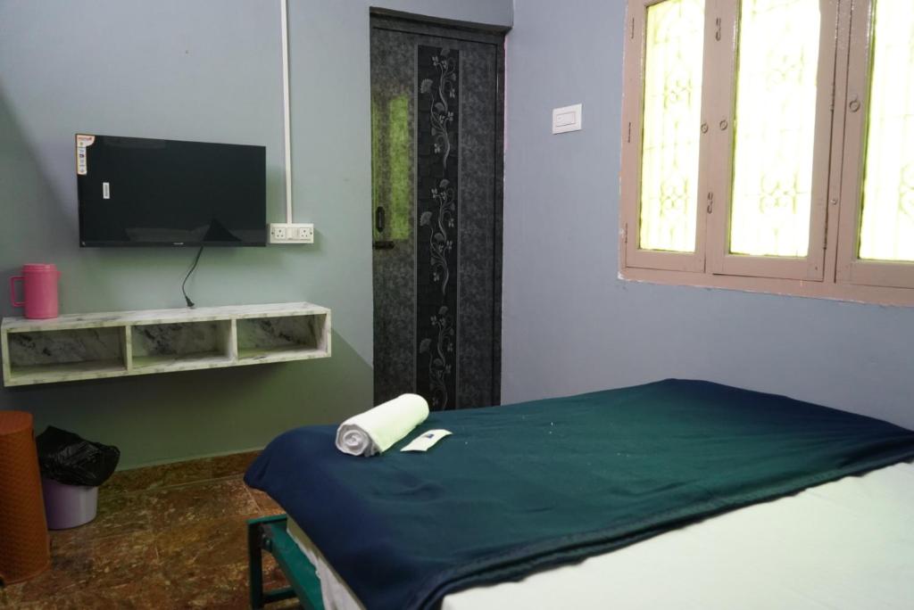 a room with a bed and a flat screen tv at I grand Home Stay in Tallākulam