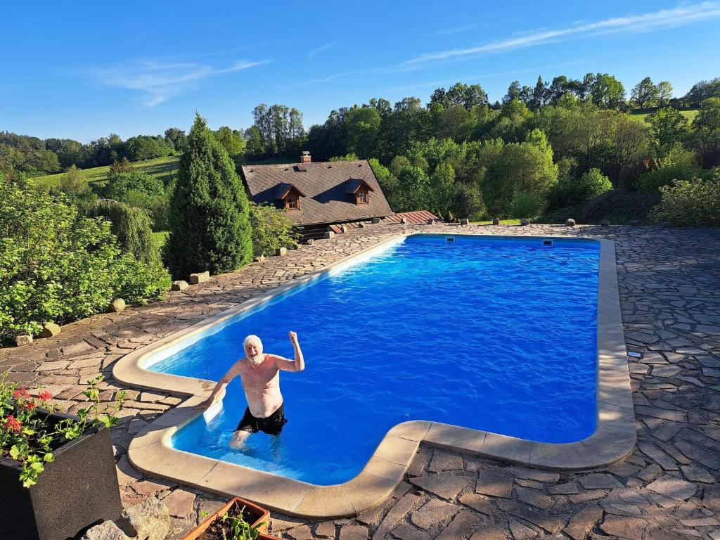 a man is in a swimming pool at Private Pool Villa in Stupna in Pecka