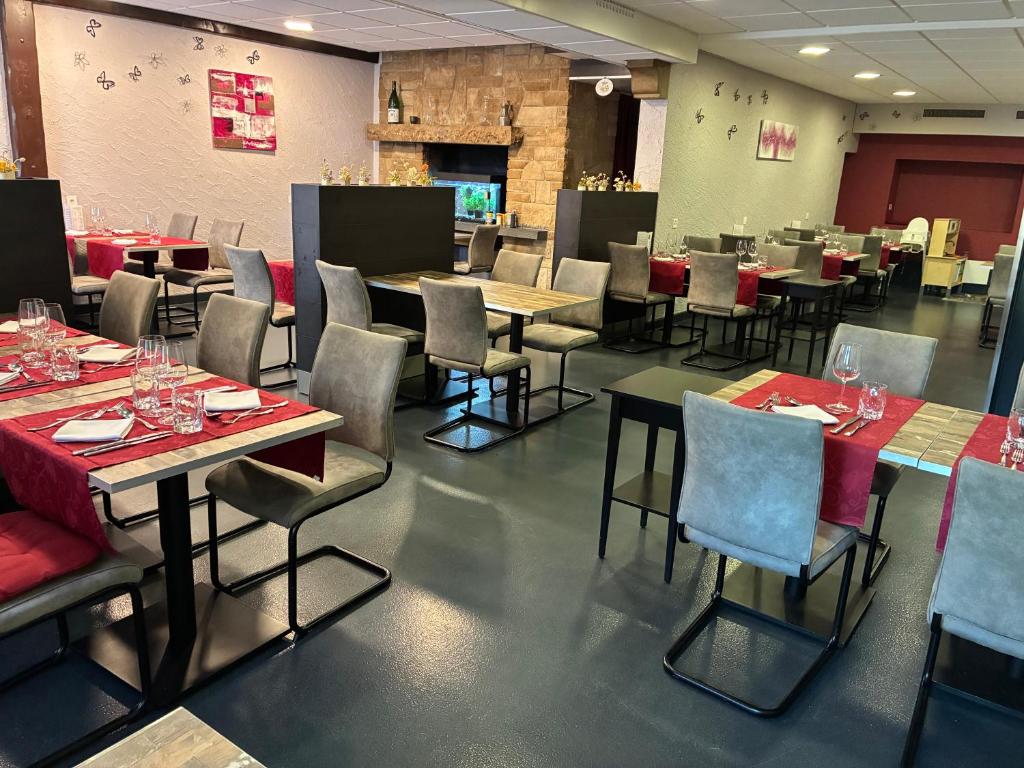 a dining room with tables and chairs with wine glasses at Hôtel- restaurant Le Bras d'Or in Mathod