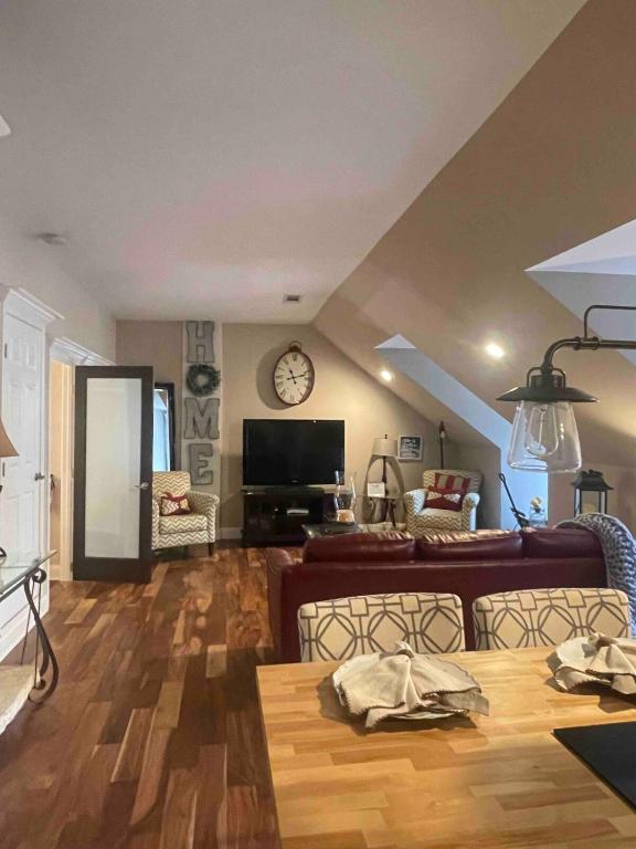 Una sala de estar con un sofá y un reloj en la pared. en Full 1 bedroom apartment to yourself, en Stockbridge